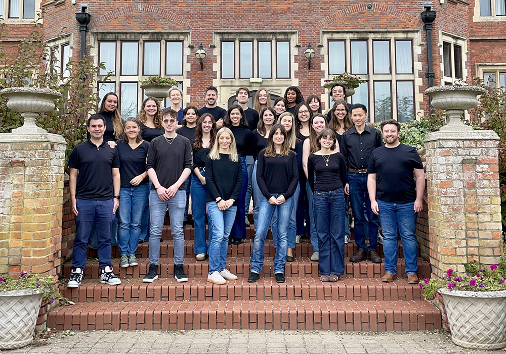 The members of the Vento-Tormo Lab outside of a red brick country house.